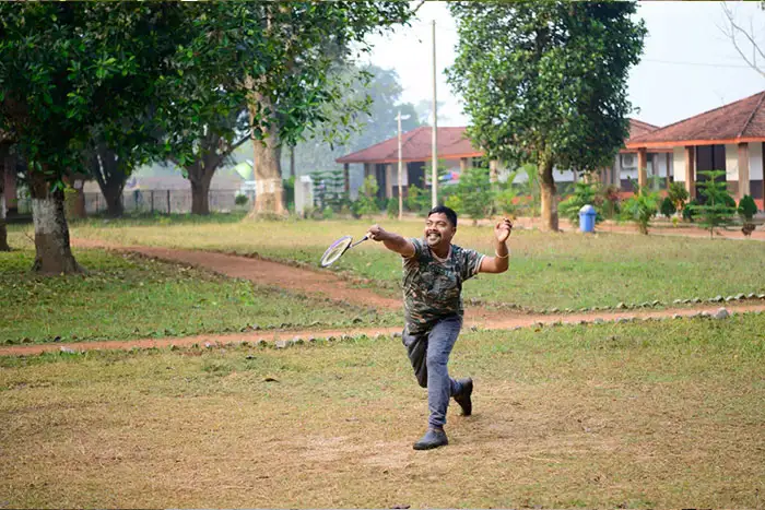 Visitor playing badminton in an open recreation area